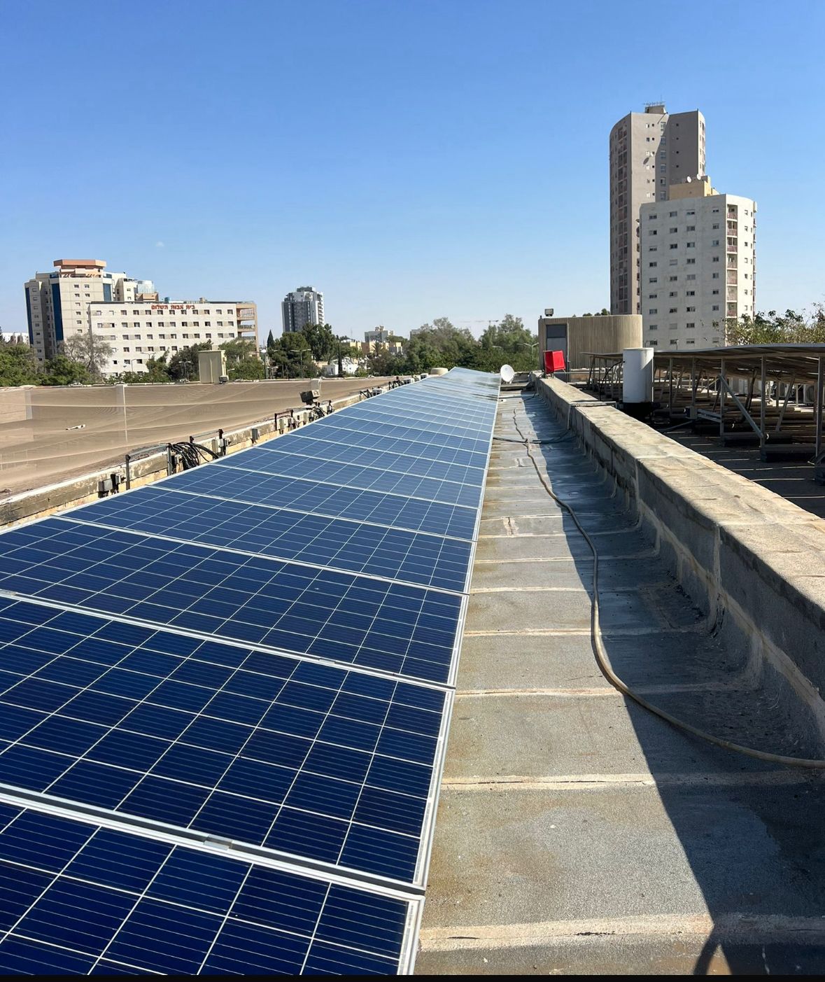מערכת סולארית מקצועית על גג מבנה מסחרי עם נוף עירוני